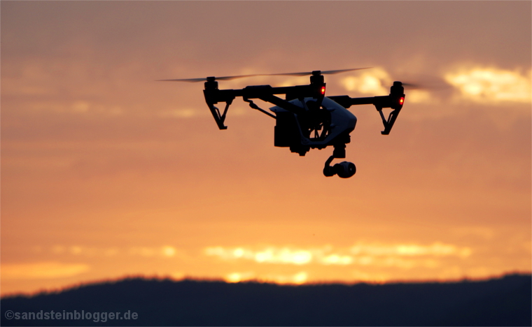 Sonnenaufgang - Quadrocopter vor rotglühendem Himmel