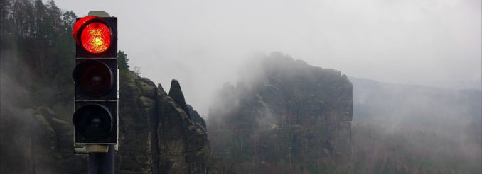 Rote Ampel vor nassen Felsen