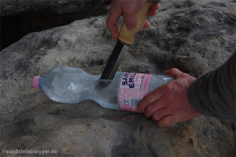 Plasteflasche wird mit Messer aufgeschnitten, gefrorenes Trinkwasser