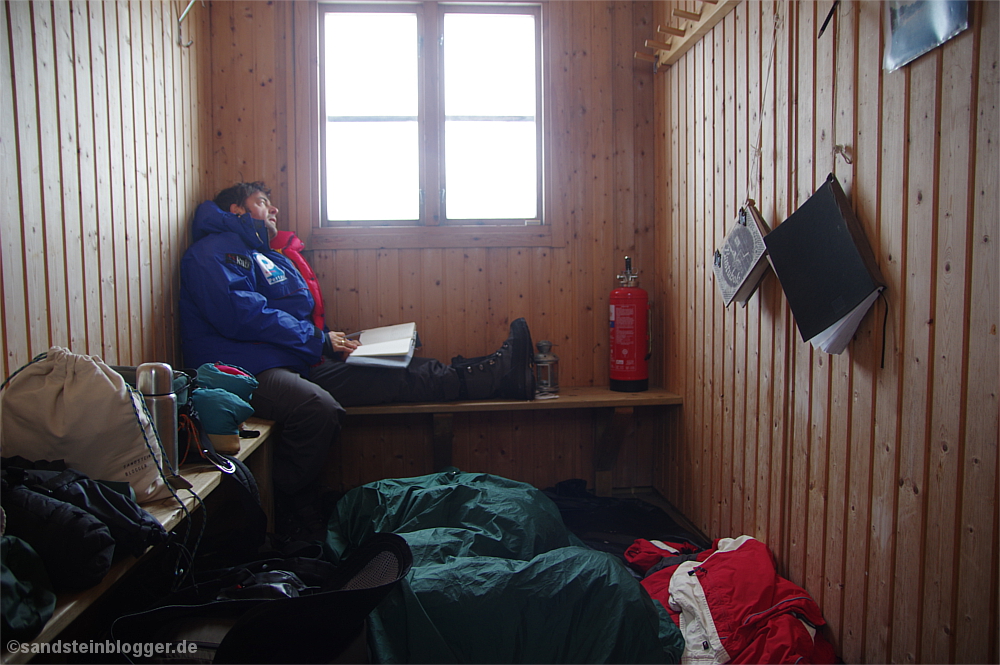 Mann in Daunenjacke in der Sauna