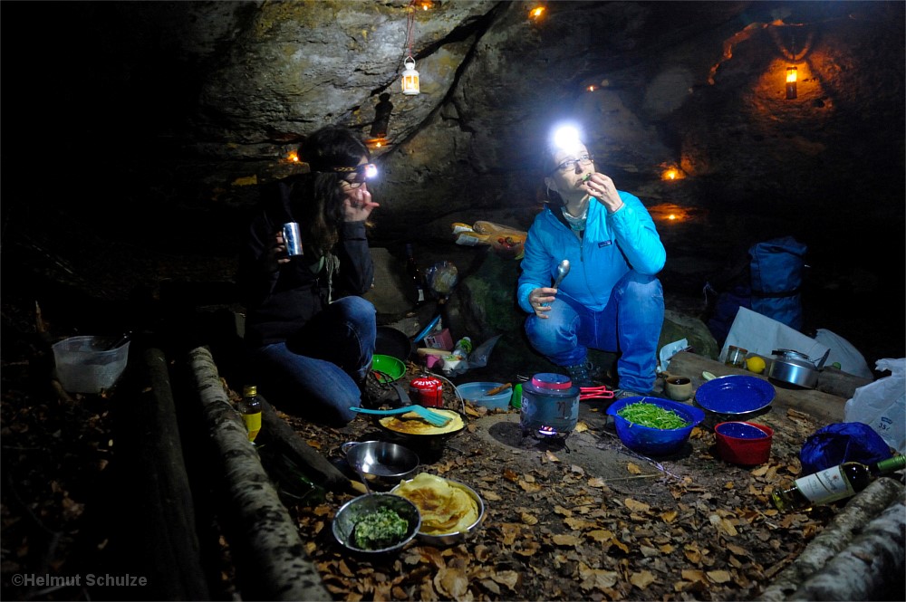 Frauen kochen unterm Felsüberhang