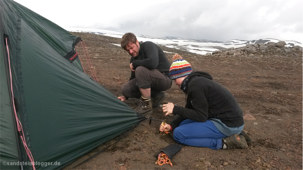 Mann und Junge bauen ein Zelt auf