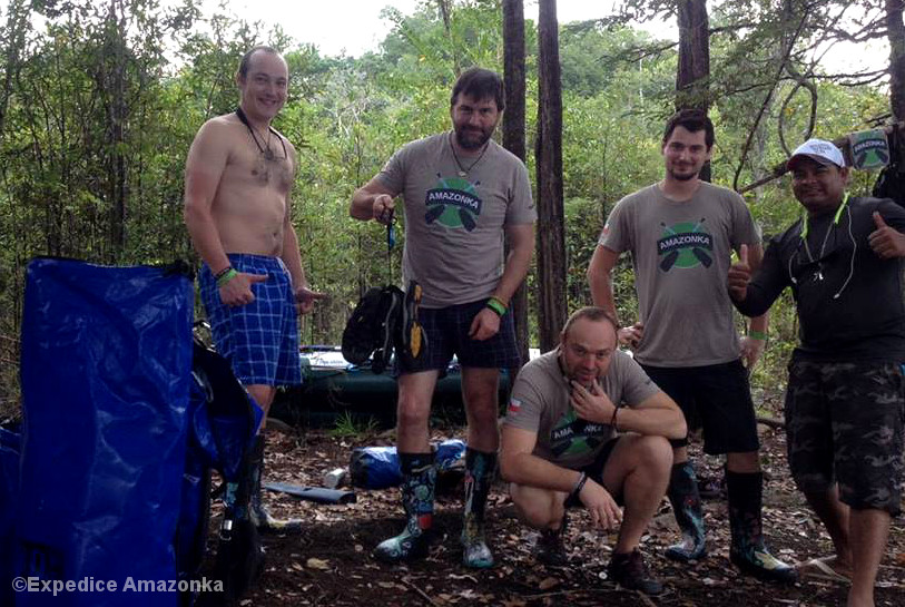 Fünf Männer mit Paddelausrüstung im Wald