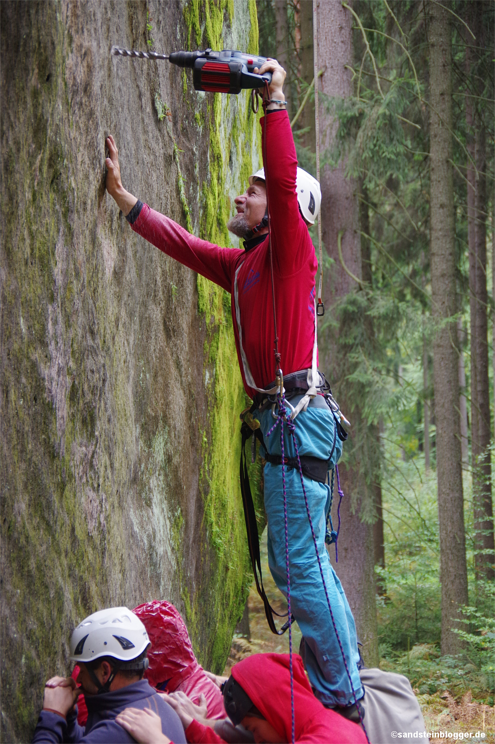 Mann bohrt ein Loch in die Felswand