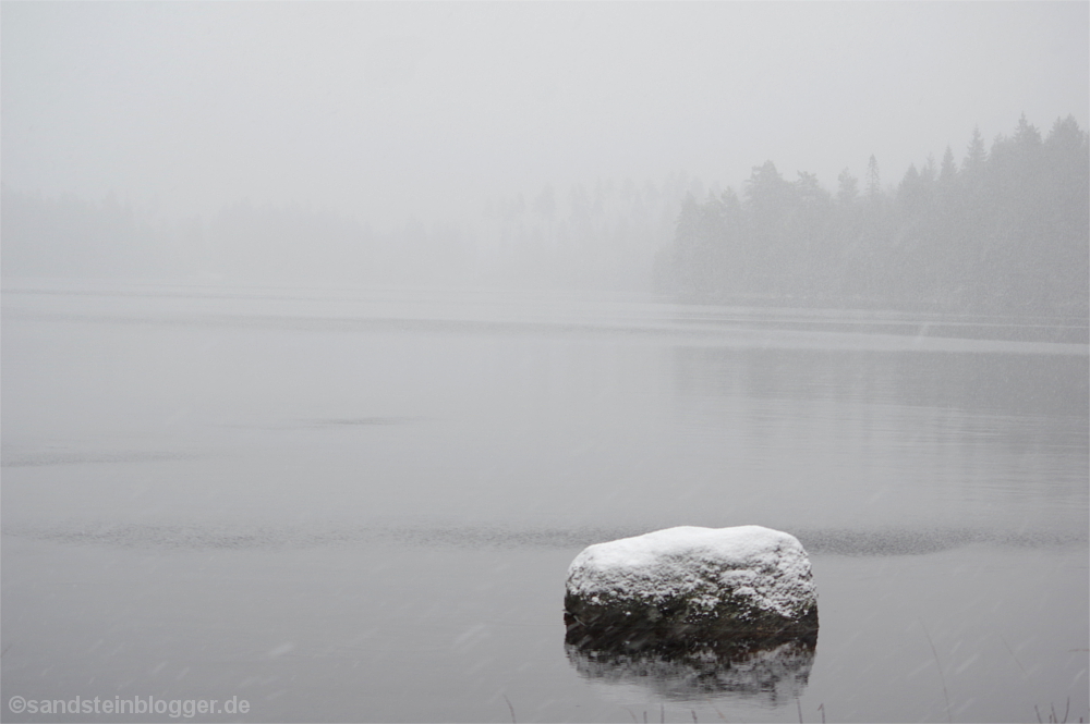 Verschneiter Stein im See