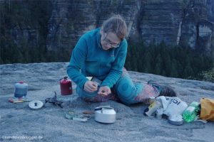 Frau mit Teekanne auf Felsplateau