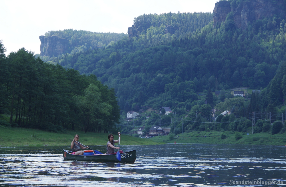 Steile Felswände hoch über dem Fluss, davor Frauen im Kanu