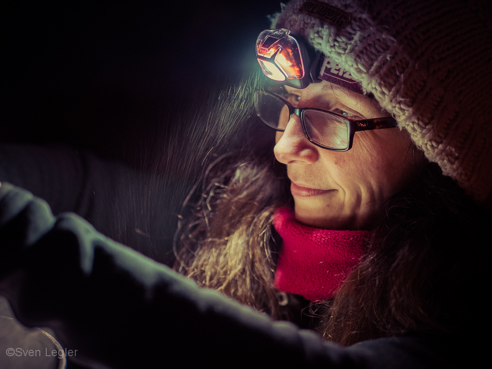 Portraitfoto - Frau mit Stirnlampe im Schneetreiben