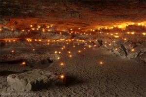 Kerzen erleuchten eine Sandsteinhöhle in der Sächsischen Schweiz