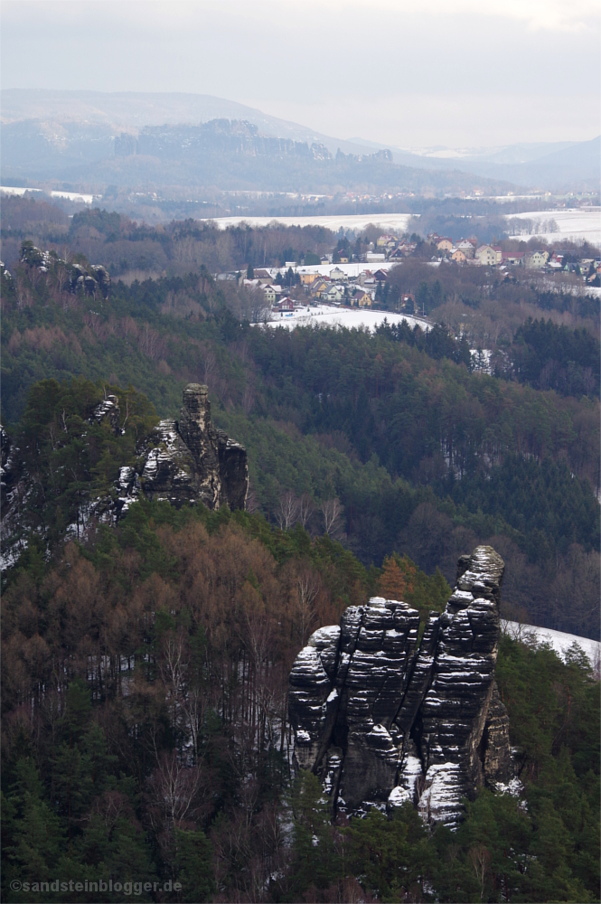 Verschneite Landschaft mit Felsen, Dörfern und Wäldern