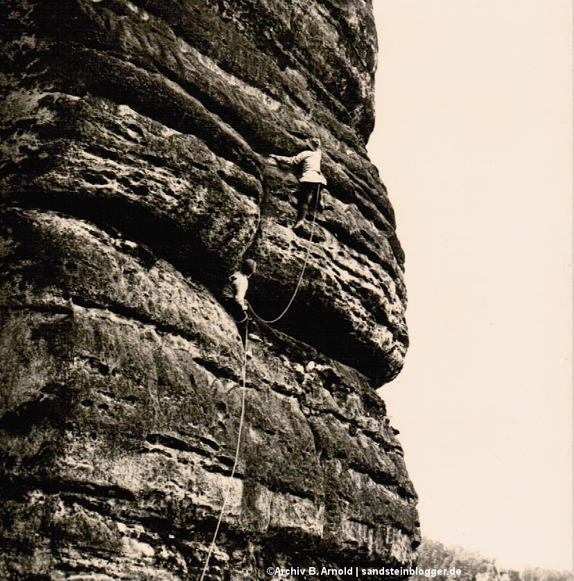 Altes Schwarzweißfoto mit Felswand und zwei Kletterern