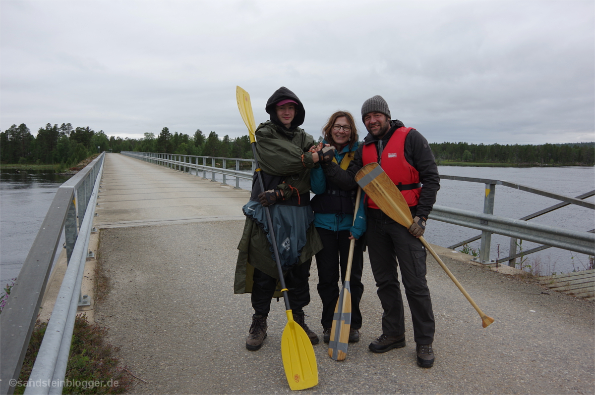 Drei Paddler auf einer Brücke an der finnisch-russischen Grenze