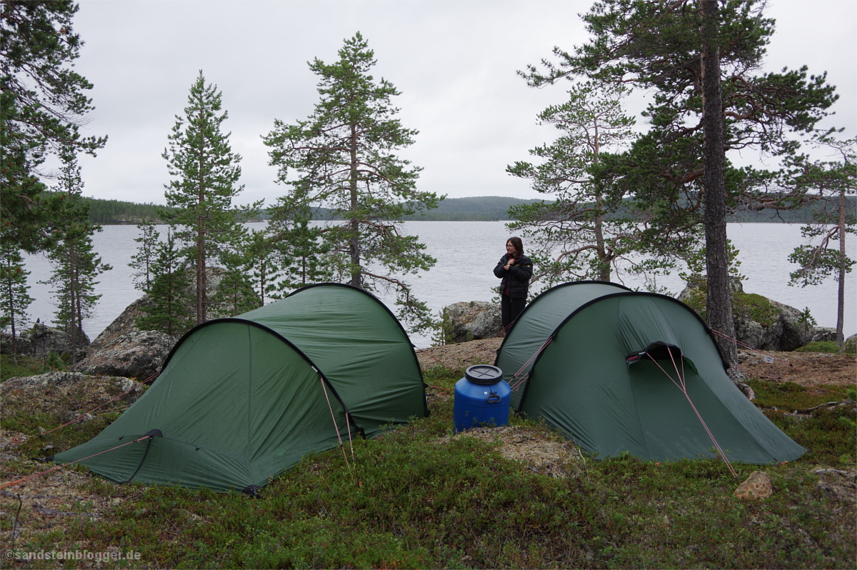 Zwei Zelte, dazwischen eine Frau - im Hintergrund der See