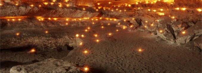 Sandsteinhöhle voller brennender Teelichter