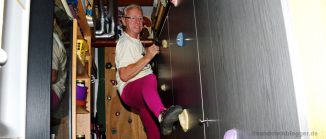 Rentner klettert im Keller an einer Schrankwand